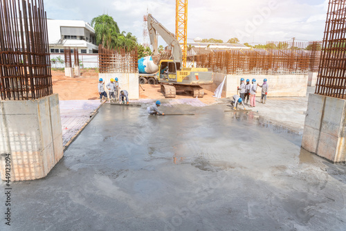 Group of Construction worker with excavator heavy machine and cement truck for Concrete pouring during commercial concreting floors of building in construction site