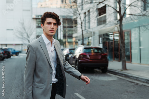 young man in casual suit walking down a street