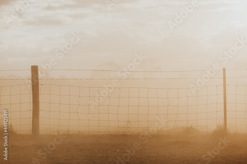 Wire fence in brown haze photo