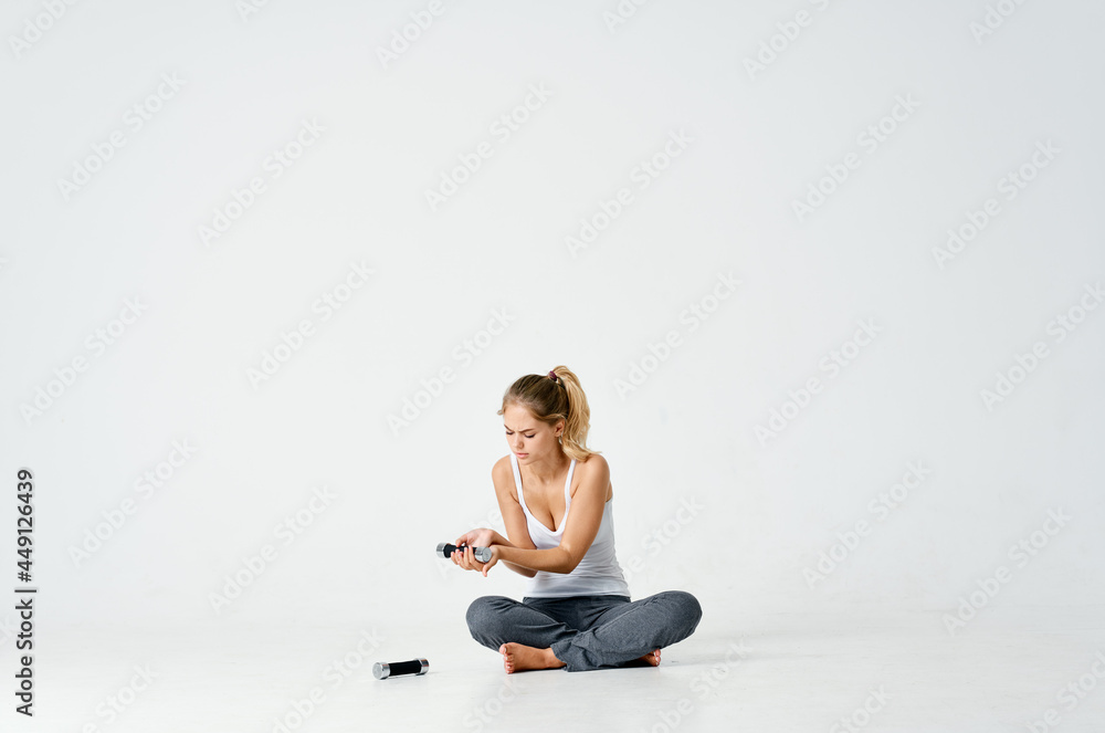 Fototapeta premium sportive woman sitting on the floor dumbbell in hands charging motivation energy exercise