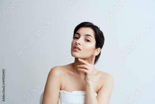 woman with bare shoulders face cream moisturizing and skin care