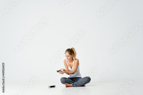 sportive woman sitting on the floor dumbbell in hands charging motivation energy exercise