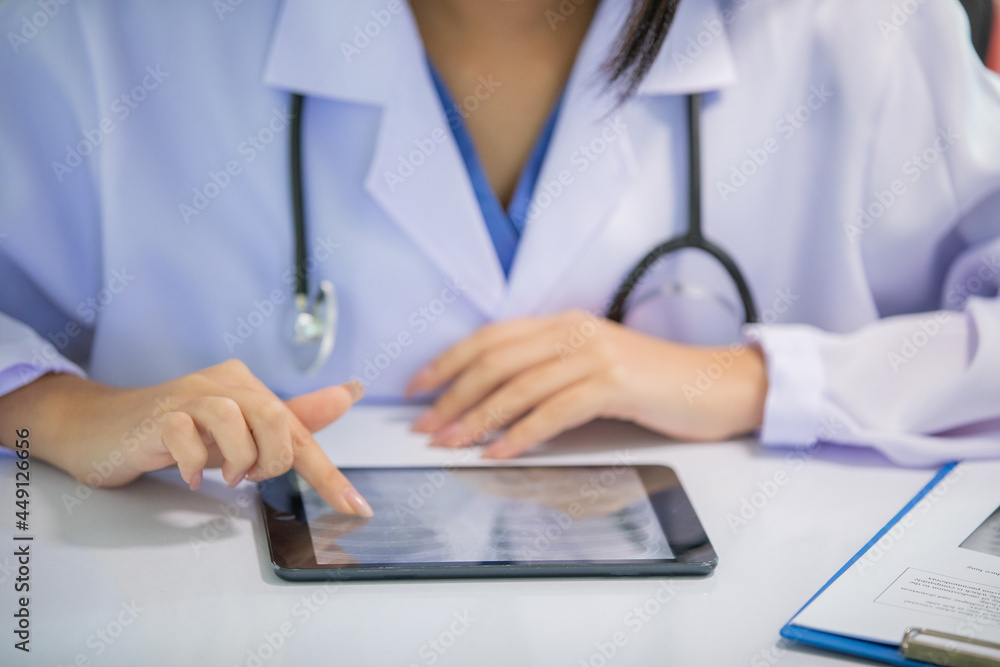 Asian women doctor working and analyzing x-ray images at hospital office Asian women doctor working and analyzing x-ray images at hospital office