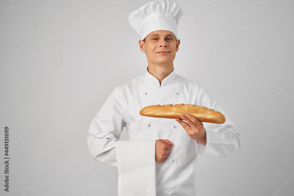 man in chef's clothes Professional with a baguette in his hands fresh product work man in chef's clothes Professional with a baguette in his hands fresh product work