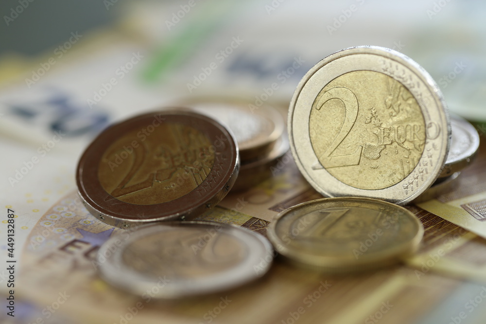 Euro coins and euro banknotes on a blurred green background.Money. Two euro coins. European currency. Finance and savings. High quality photo Euro coins and euro banknotes on a blurred green background.Money. Two euro coins. European currency. Finance and savings. High quality photo