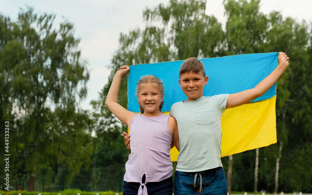 Obraz premium Ukrainian children boy and girl with yellow and blue flag of Ukraine in stadium. Ukraine's Independence Flag Day. Constitution day. flag symbols of Ukraine. Kyiv, Kiev day