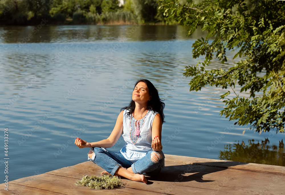 Woman Yoga - relax in nature. sitting on pier lake