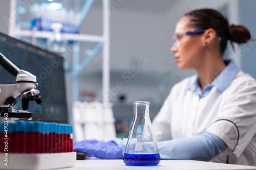 Scientist researcher woman typing pharmaceutical vaccine innovation results researching biochemistry experiment. Specialist doctor working at genetic dna infection in pharmacology hospital laboratory