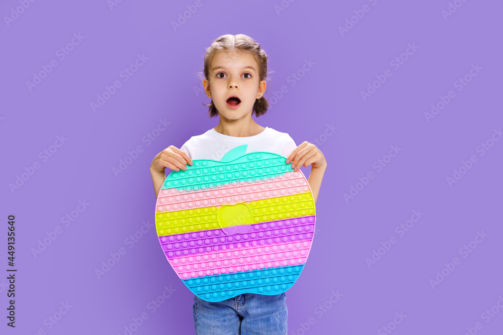 Surprised kid holding huge apple anti stress bubble. motor skills. pop it fun. child holding color popit fidget Surprised kid holding huge apple anti stress bubble. motor skills. pop it fun. child holding color popit fidget