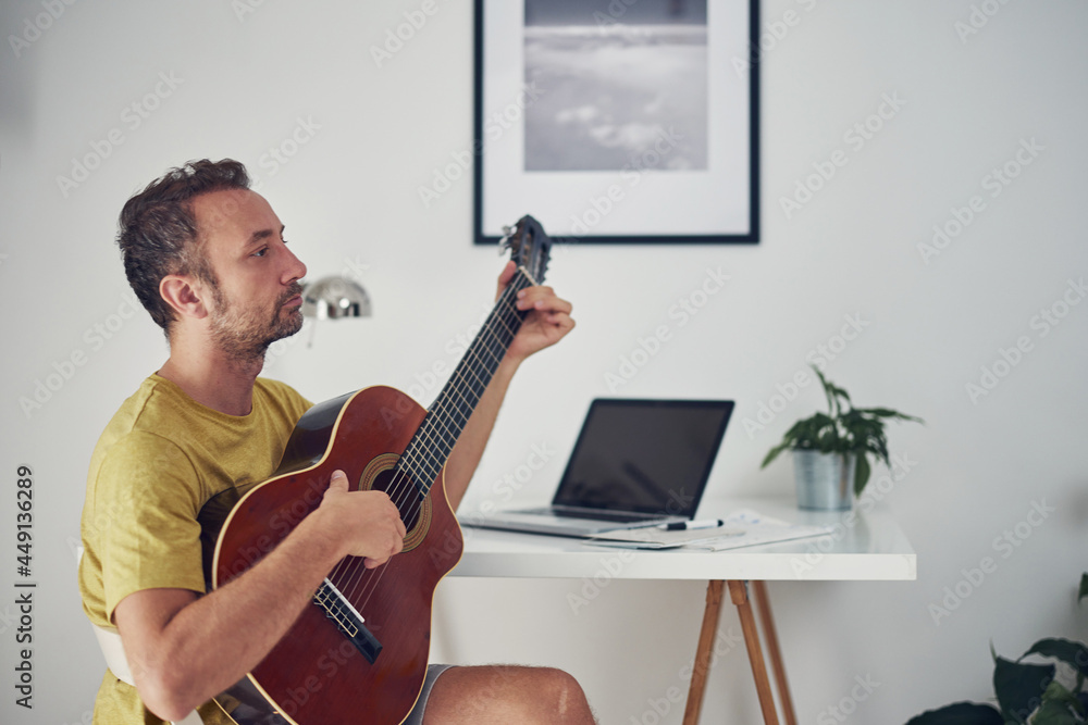 Man playing acoustic guitar at home. Man playing acoustic guitar at home.