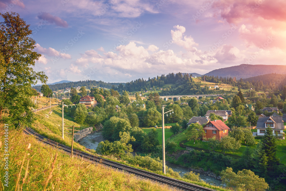 View of the city on slopes of mountains during sunset in summer. Vorokhta city in the Carpathian Mountains, Ukraine