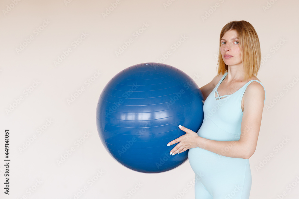 pregnant woman in blue jumpsuit with fitness ball in training pregnant woman in blue jumpsuit with fitness ball in training