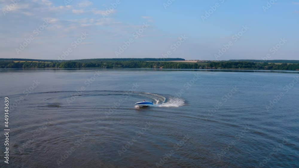 Motorboat on blue water surface. Tourists travel in a high-speed boat in the sea. White foam after the boat sailing on water. Aerial view Motorboat on blue water surface. Tourists travel in a high-speed boat in the sea. White foam after the boat sailing on water. Aerial view