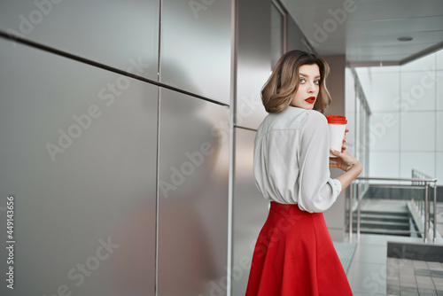 pretty woman near building with cup of coffee posing fashion lifestyle