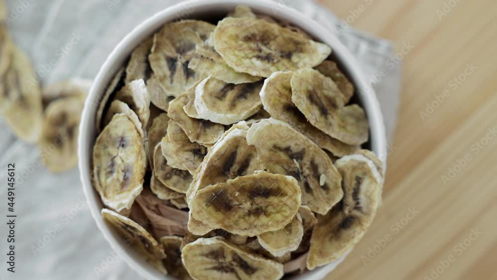 serving of dried banana chips for a healthy diet in a plate. Camera rotation serving of dried banana chips for a healthy diet in a plate. Camera rotation