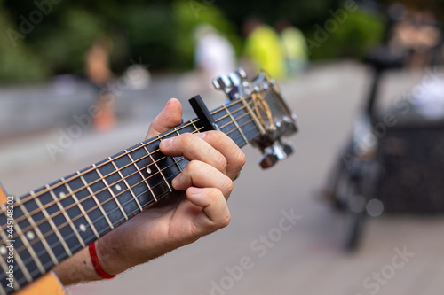 a man's hand plays a chord on an acoustic guitar. close-up