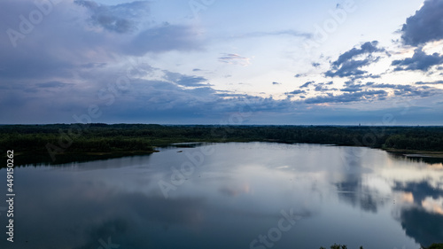 Beautiful view of a lake under a dramatic sunset sky reflected in the water. Nature and Travel Tourism concept. High quality photo