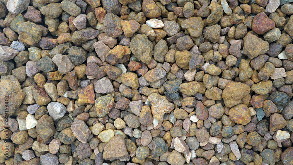 Granite gravel of macadam, Rock brown crushed for construction on the ground, Scree texture background Granite gravel of macadam, Rock brown crushed for construction on the ground, Scree texture background