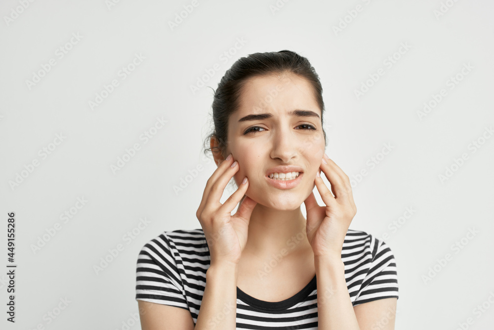 woman in striped t-shirt holding face toothache discontent woman in striped t-shirt holding face toothache discontent