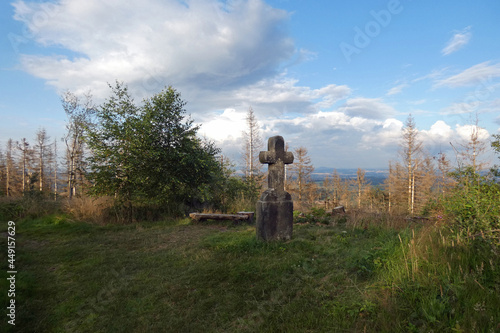 injured nature and the old stone cross on the hiking trail photo