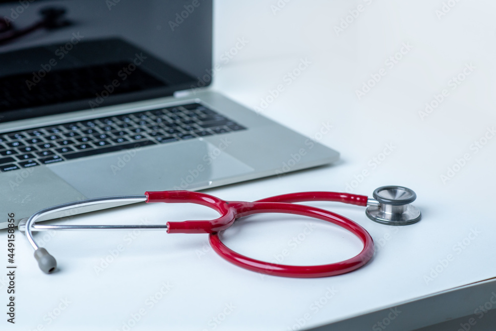 Stethoscope and computer on white desk in white background Stethoscope and computer on white desk in white background