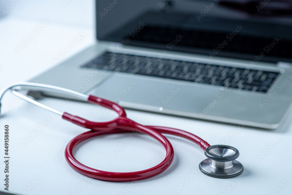 Stethoscope and computer on white desk in white background Stethoscope and computer on white desk in white background