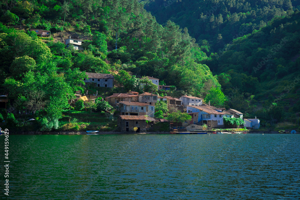 Casas a pie del cerro en el Rio Miño, Galicia. 