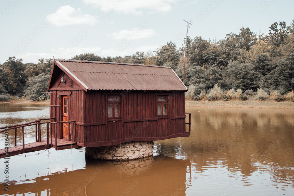 Old wooden house on a lake. Isolated building in nature. Arstistic photo with retro and melancholic vibes. Black and white image. Old wooden house on a lake. Isolated building in nature. Arstistic photo with retro and melancholic vibes. Black and white image.