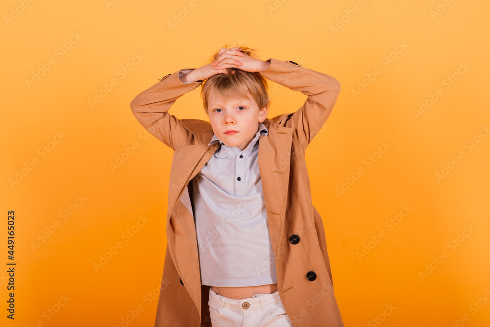 Grimacing emotional redhead fasion boy posing in yellow studio Grimacing emotional redhead fasion boy posing in yellow studio