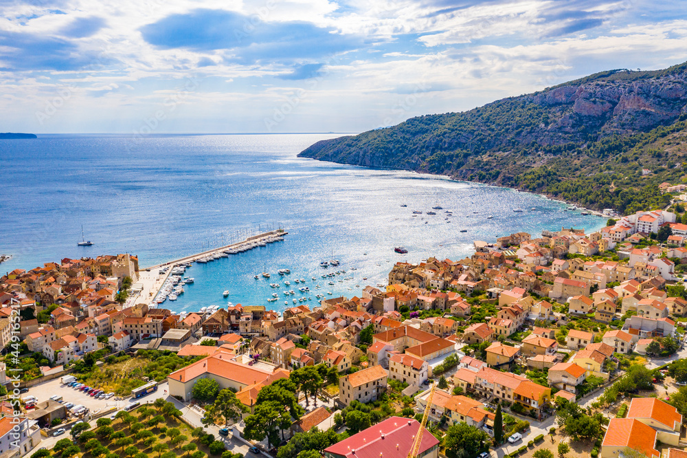 Aerial panoramic view of city Komiza - the one of numerous port towns in Croatia, is a lot of moored sailboats of a regatta