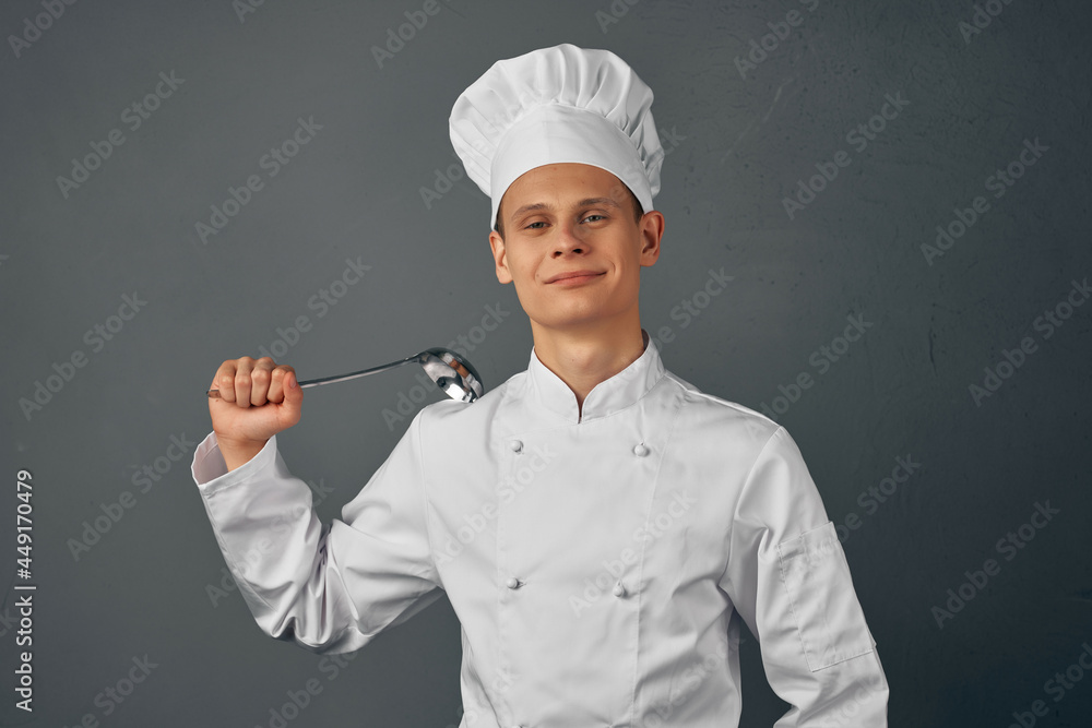 a chef with a cap on his head a scoop in his hands cooking food dark background a chef with a cap on his head a scoop in his hands cooking food dark background