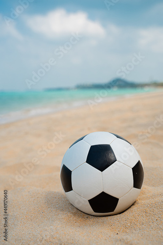 Summer soccer ball on the sand on the beach by the sea