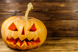 Spooky Halloween pumpkin jack-o-lantern on a wooden background