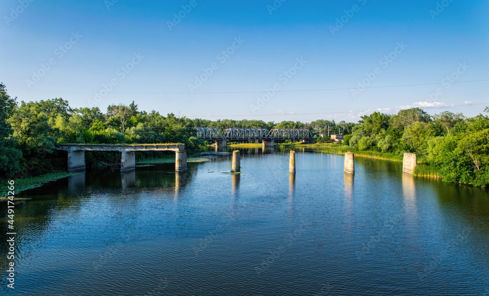 Ancient ruined stone bridge and serene river Ancient ruined stone bridge and serene river