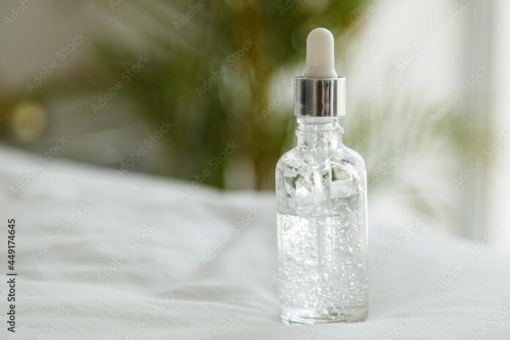 Bottle of the face serum on green leaf background Bottle of the face serum on green leaf background