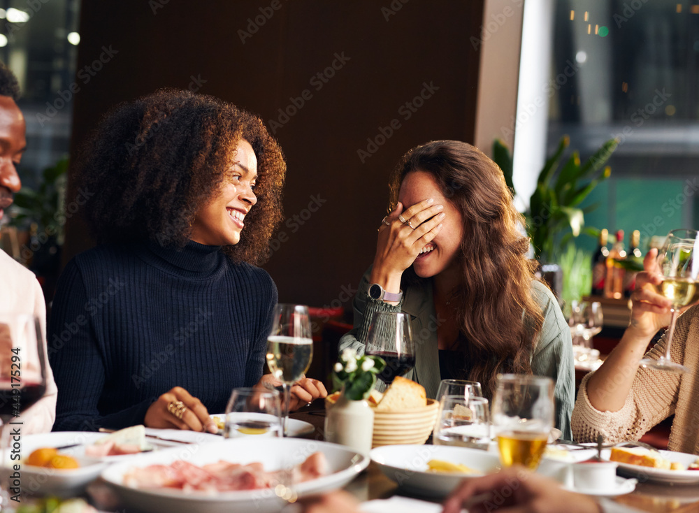Friends telling jokes at dinner in restaurant Friends telling jokes at dinner in restaurant