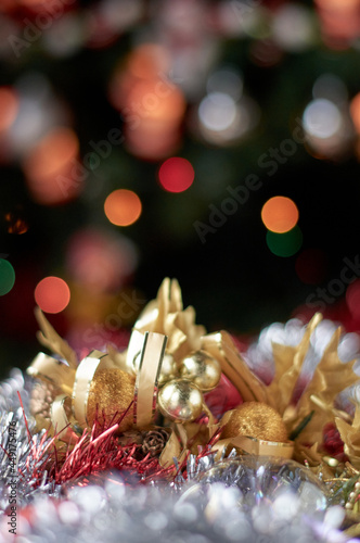 Background with bokeh colors and silver and gold Christmas ornaments at the bottom. © jclaudiopph