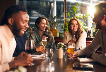Friends laughing with drinks in bar