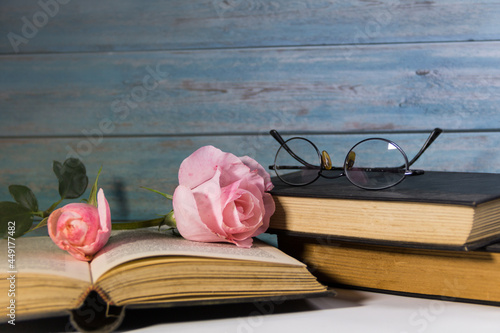 pink roses and books on rustic wood photo