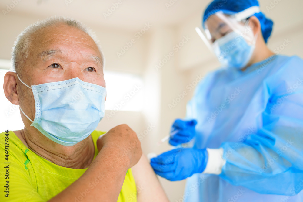 Doctor doing vaccine injection to senior man Doctor doing vaccine injection to senior man