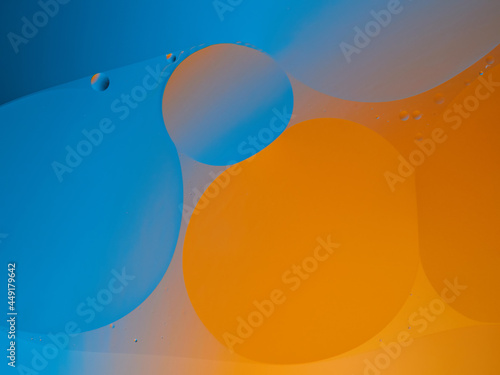 Closeup of oil drops motion on water surface. Colorful abstract macro background of oil drops on water surface with air bubbles inside