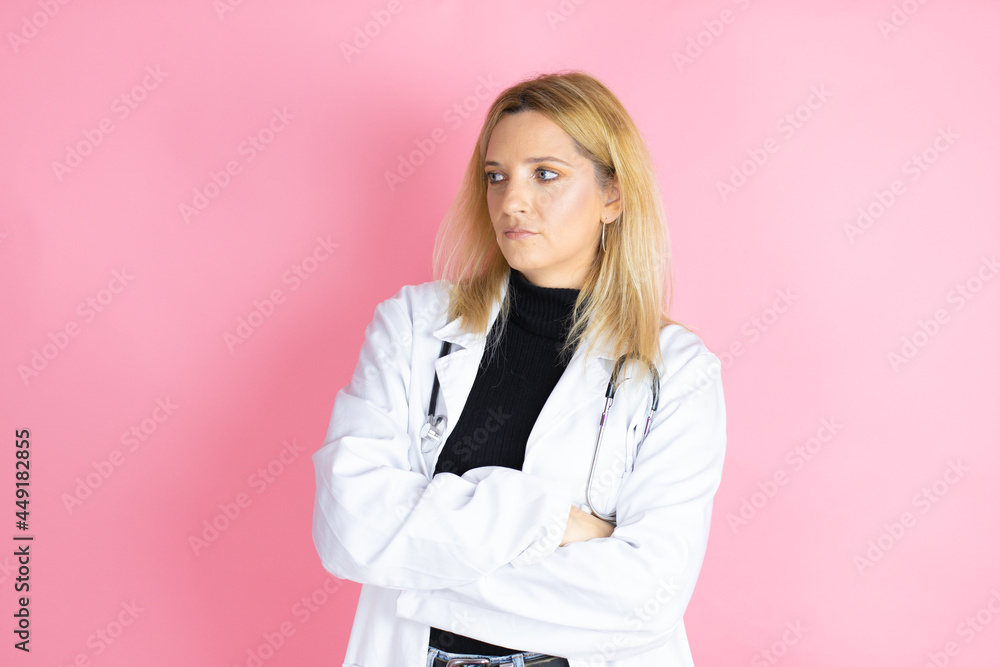 Young blonde doctor woman wearing stethoscope standing over isolated pink background thinking looking tired and bored with crossed arms Young blonde doctor woman wearing stethoscope standing over isolated pink background thinking looking tired and bored with crossed arms