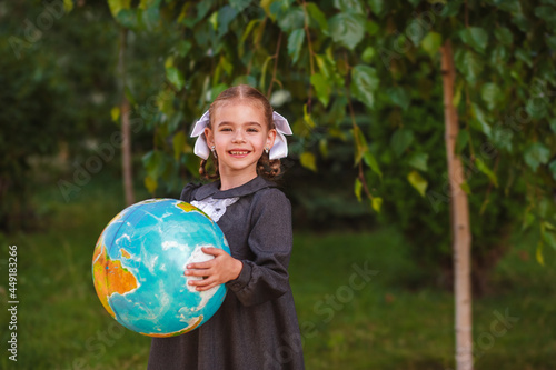 Concept - education. Back to school. cheerful schoolgirl with a globe outdoors 