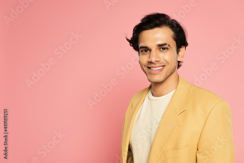 happy young man in yellow blazer smiling on pink © LIGHTFIELD STUDIOS