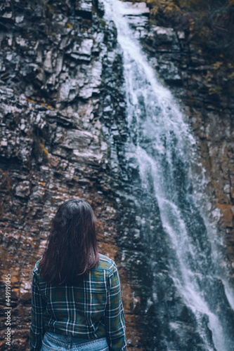 woman in casual clothes looking at waterfall