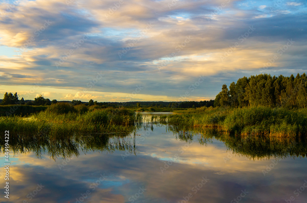 Fototapeta premium Beautiful calm blue landscape at the sunset of the lake. Reflection of clouds in the water