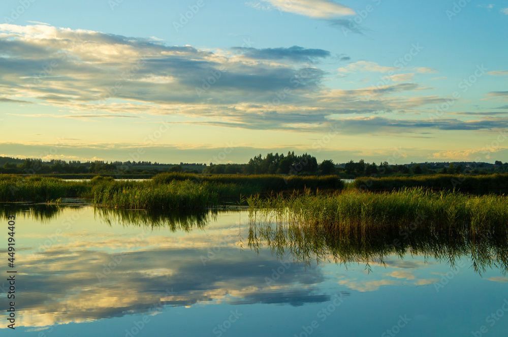 Fototapeta premium Beautiful calm blue landscape at the sunset of the lake. Reflection of clouds in the water