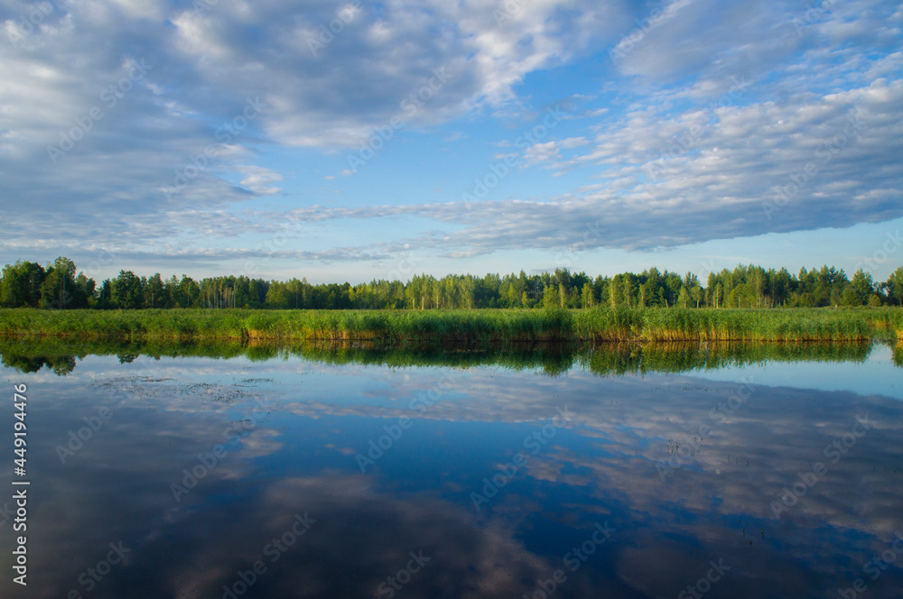Beautiful calm blue landscape at the sunset of the lake. Reflection of clouds in the water Beautiful calm blue landscape at the sunset of the lake. Reflection of clouds in the water