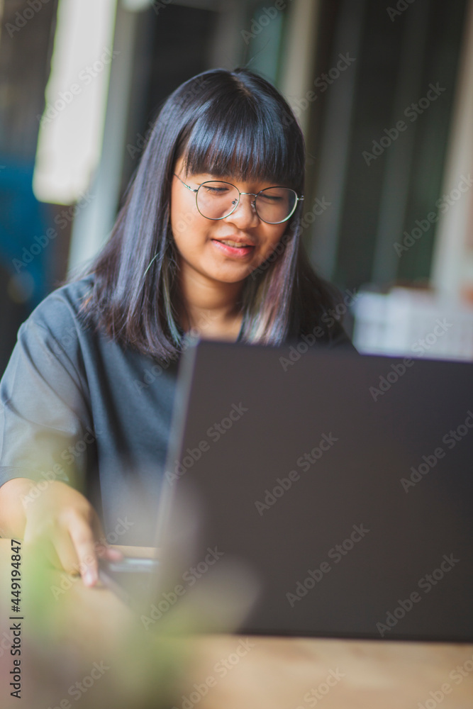 asian teenager working on computer laptop in home living room asian teenager working on computer laptop in home living room