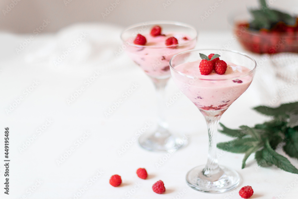 Delicious raspberry mousse with mint on a white table Delicious raspberry mousse with mint on a white table